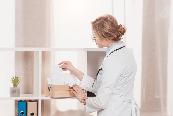 вид сбоку врача в белом халате, работающего с холостыми в клинике
 - Фото, изображение