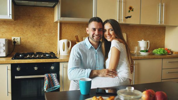 Portrait of happy smiling couple sittting in the kitchen early morning at home - Foto, Bild