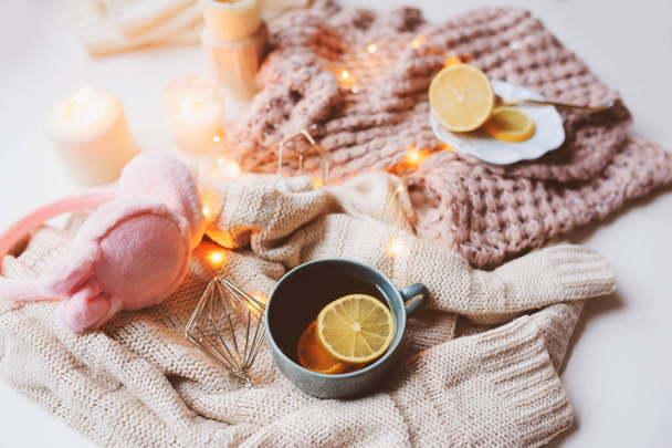 Cozy winter morning at home. Hot tea with lemon, knitted sweaters and modern interior details. Flat lay still life composition. - Foto, imagen