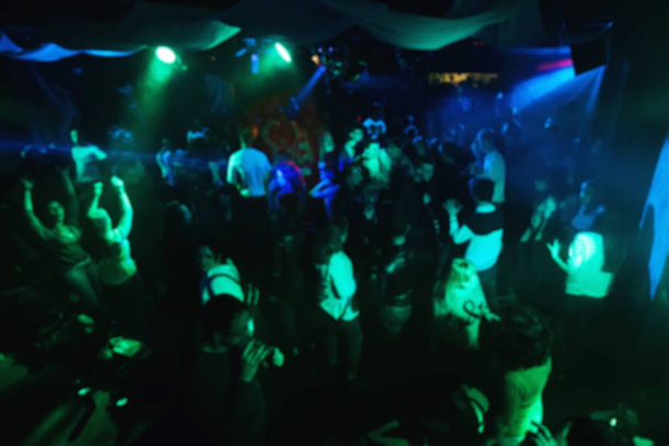 緑の照明と夜のクラブのダンスフロアでコンサートで人のぼやけたシルエット - 写真・画像