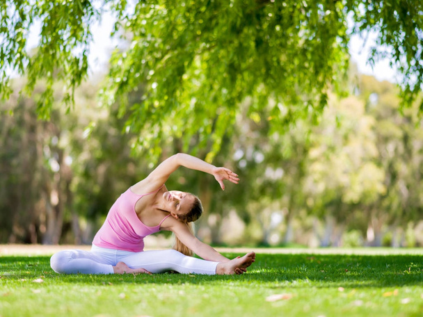 Young woman doing yoga in the park - Foto, immagini