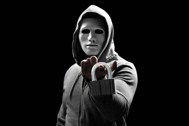 Hacker in mask with lock on dark background - Foto, afbeelding