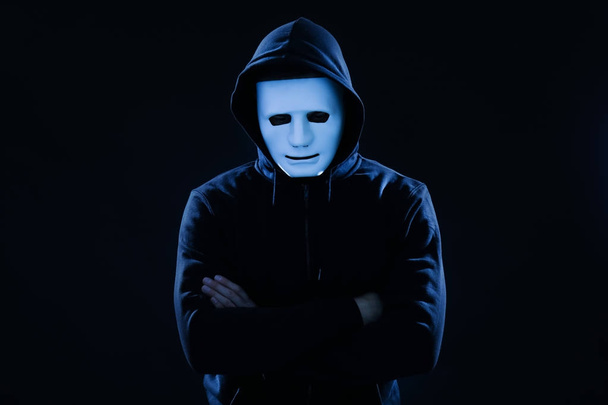 Hacker σε μάσκα σε σκούρο φόντο - Φωτογραφία, εικόνα