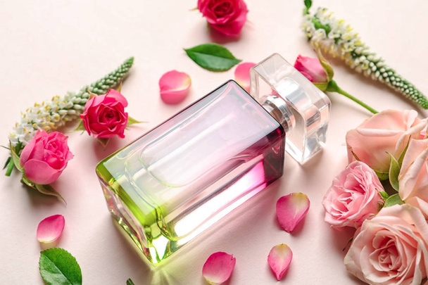 Bottle of perfume with flowers on light background - Фото, изображение