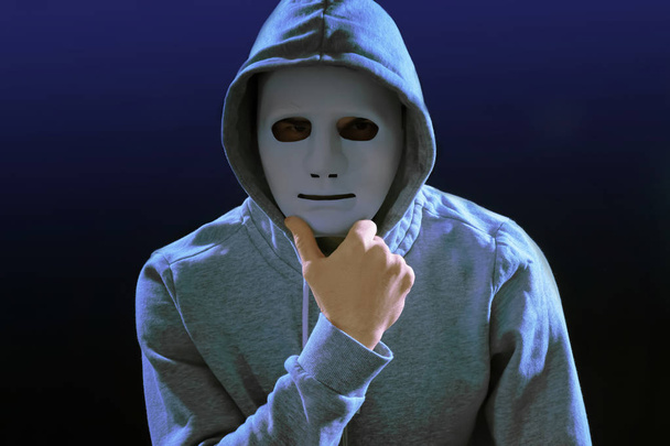 Hacker in mask on dark background - Фото, изображение