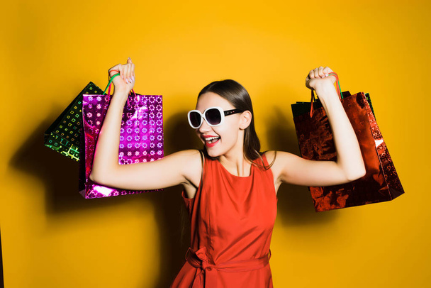 happy laughing young girl in sunglasses went shopping and presents on a black Friday - 写真・画像
