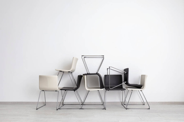 Composición con sillas modernas cerca de la pared de luz
 - Foto, imagen