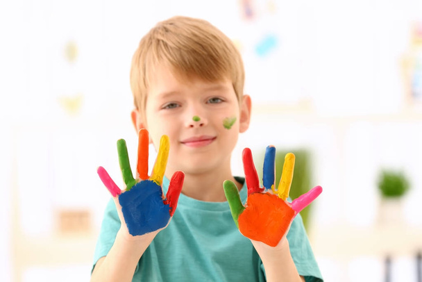 Cute boy with paint on hands against blurred background - Foto, Imagem