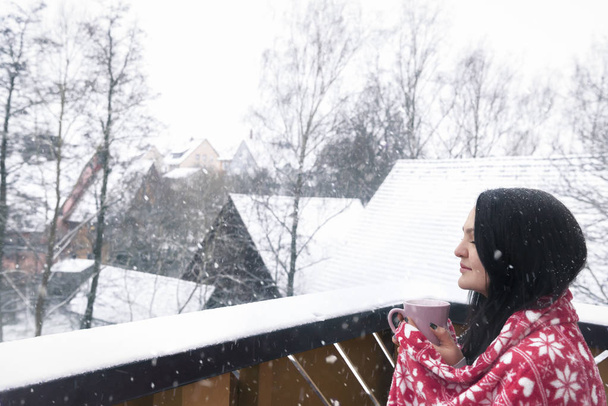 Frau mit Getränk und Decke unter Schneefall - Foto, Bild