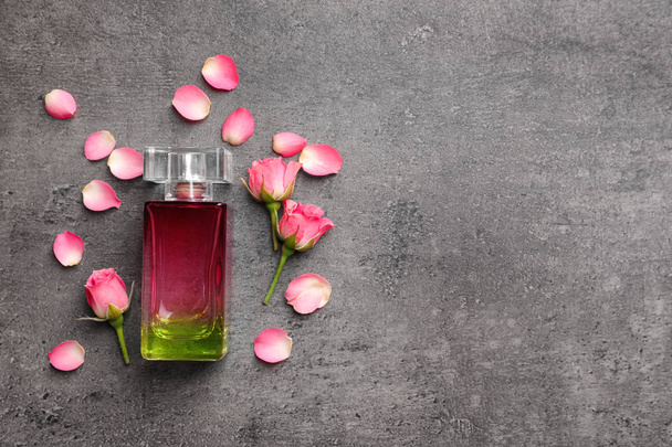Bottle of perfume and roses on grey background - Photo, Image
