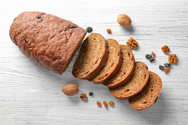 Yummy fresh bread with walnut and raisins on wooden background - Foto, Imagen