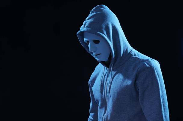 Hacker in mask on dark background - Foto, afbeelding