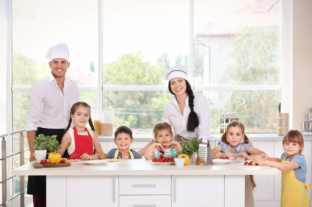 Two chefs and group of children during cooking classes - Fotoğraf, Görsel
