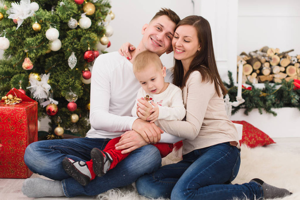 Happy young cheerful parents with cute little son. Child boy sit - Foto, imagen