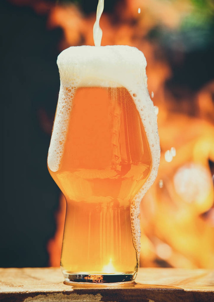Taza de cerveza sobre madera presentada. Fotografía de naturaleza muerta de vidrio de cerveza ligero
. - Foto, Imagen