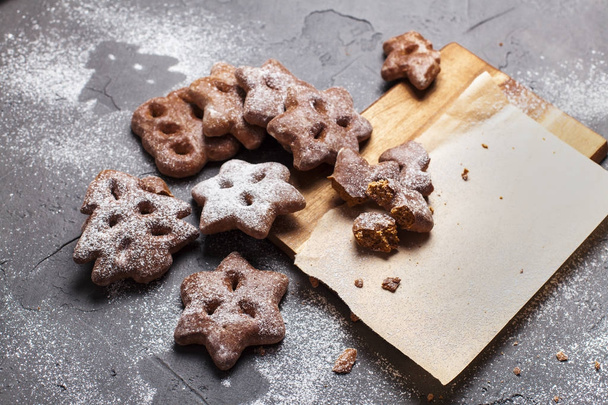 Різдвяне печиво з цукровою пудрою на дерев'яній дошці на сірому фоні
 - Фото, зображення