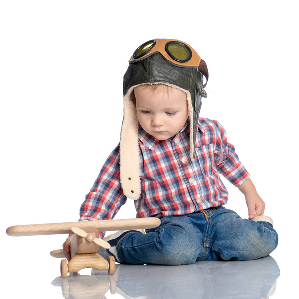 Mały chłopiec w cap pilotów i drewniany samolot w ręku - Zdjęcie, obraz