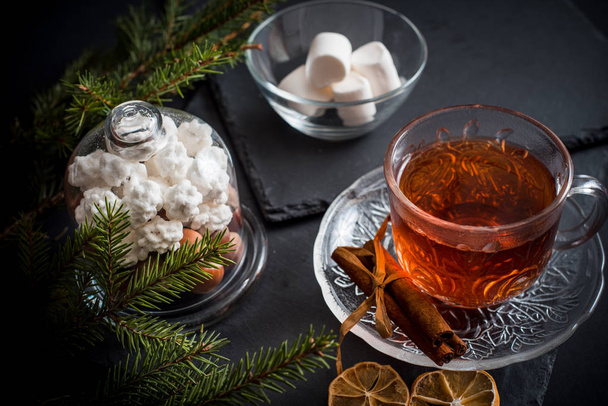 Sweet winter holidays background with various cookies and cup of hot spicy black tea on dark rustic table - Foto, Bild