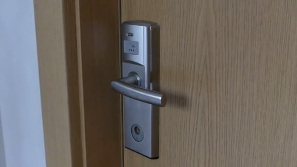 Una carta di plastica viene applicata a una maniglia della porta. La porta si apre
. - Filmati, video
