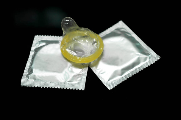 Condom put on silver packages isolate on  black background. - Valokuva, kuva