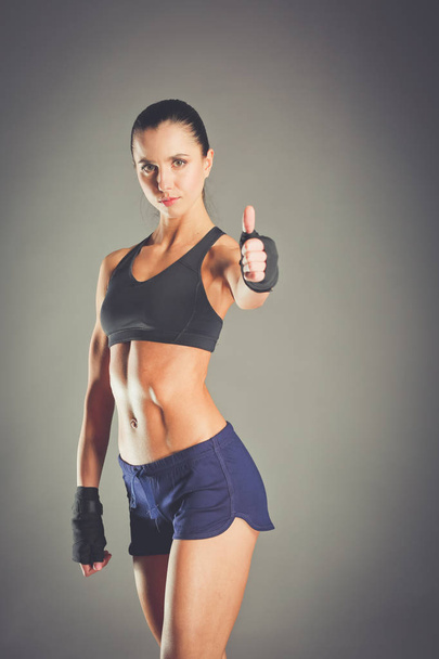 Portrait of a happy fitness woman showing ok sign. - Foto, afbeelding