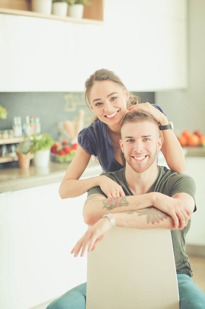 Beautiful young couple is having fun in kitchen at home - Фото, зображення
