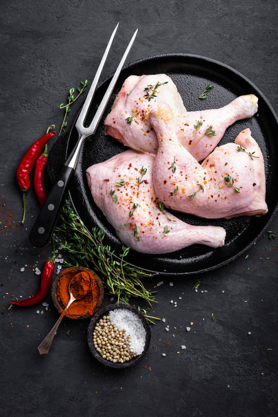 Raw chicken quarters, legs in a pan on a dark background. Top view. - Fotó, kép