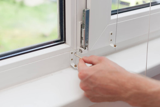 Handyman ripara finestra di plastica con un esagono. Workman regola il funzionamento della finestra di plastica
. - Foto, immagini