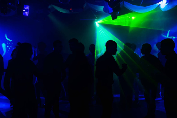 insanlar siluetleri olay altında lazer ışıkları ve konser gece kulübünde dans pistinde - Fotoğraf, Görsel