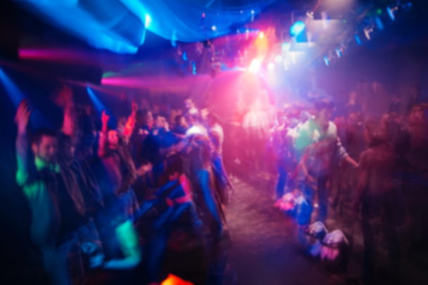 blurred silhouettes of people in nightclub at event with lighting effects at concert - Photo, Image