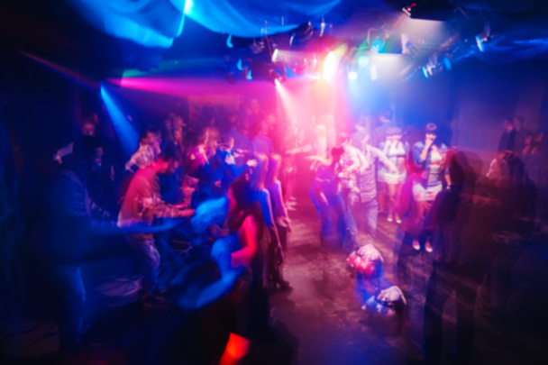 siluetas borrosas de personas en el club nocturno en concierto con un efecto conmovedor en la exposición prolongada
 - Foto, imagen