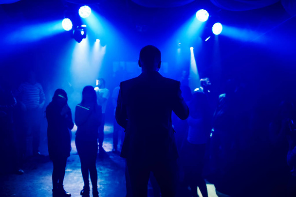 silhouette leading into nightclub scene with dancing on dance floor people at event - Foto, imagen