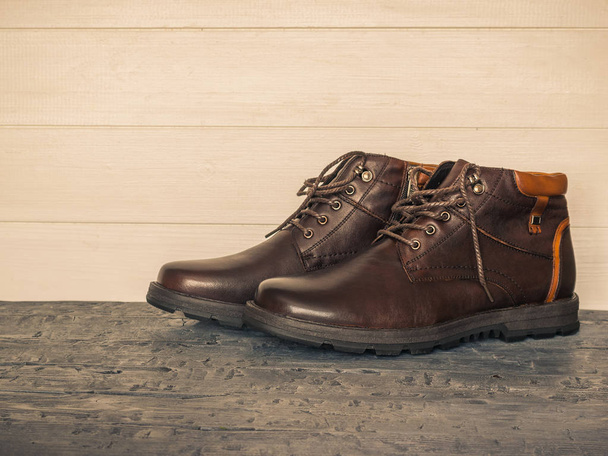 Paire de chaussures classiques marron pour hommes sur les murs en bois sombre. Chaussures pour hommes Brutal
. - Photo, image