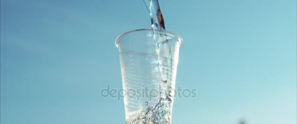 Water flowing into plastic cup. Water cooler. Closeup of hand holding cup with water. Mineral water pouring in transparent cup and overflow - Footage, Video