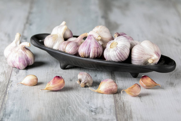 Close-up garlic bulbs and garlic cloves on wooden background. Garlic. Fresh garlic. - Φωτογραφία, εικόνα