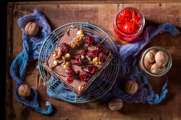 Sweet chocolate cake with walnuts and cherry - Foto, afbeelding