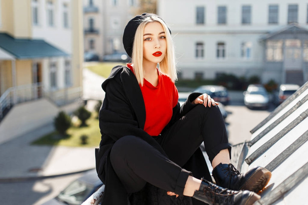Beautiful young woman in a trendy autumn coat and a fashionable beret on a sunny day - Photo, Image