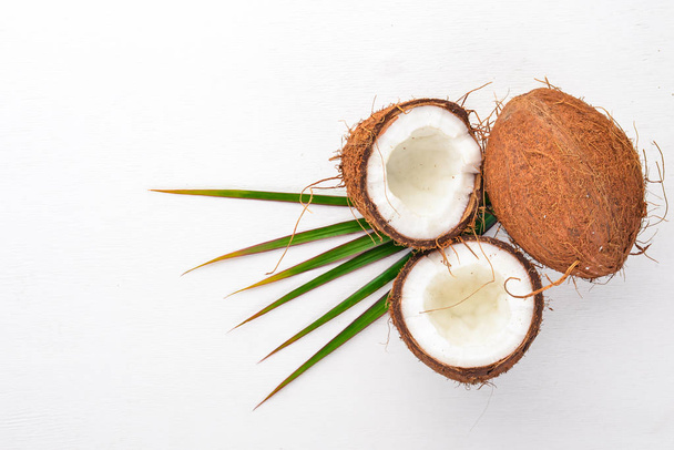 Coconut on a wooden background. Tropical fruits and nuts. Top view. Free space for text. - Foto, imagen