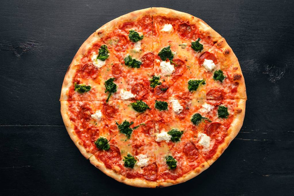 Neapolitan Pizza. Spinach, gorgonzola cheese, sausage salami. On a wooden background. Top view. - Zdjęcie, obraz