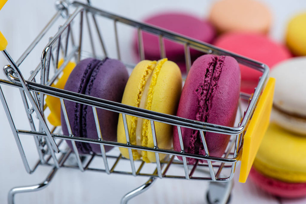 Macaroon cookies lie in a children's basket for shopping on the  - Valokuva, kuva