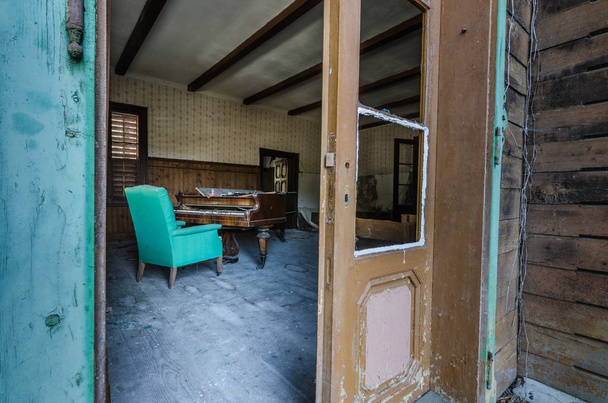 vista attraverso una porta su vecchio pianoforte in casa di foresta
 - Foto, immagini