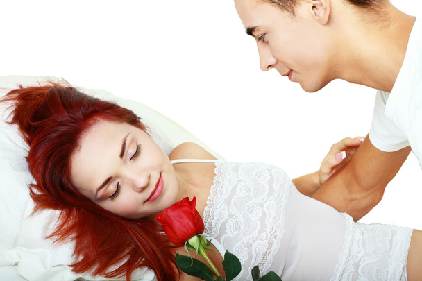 Young couple in bed with a rose - Foto, Bild