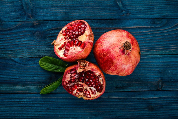 Pomegranate. Fresh fruits. On a wooden background. Top view. Free space for text. - Φωτογραφία, εικόνα