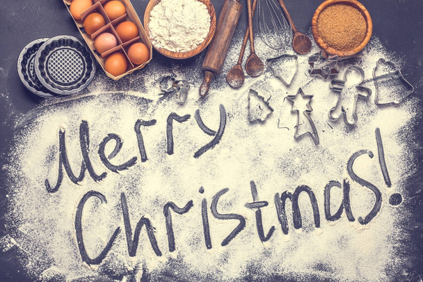 The text of a Merry Christmas from flour on a black background, horizontally - Fotoğraf, Görsel