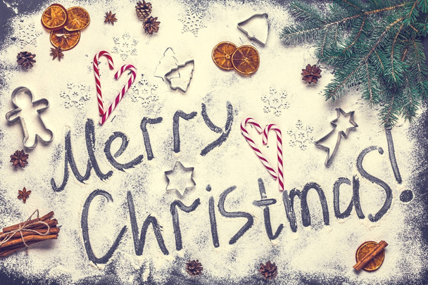 The text of a Merry Christmas from flour on a black background, horizontally - Foto, imagen
