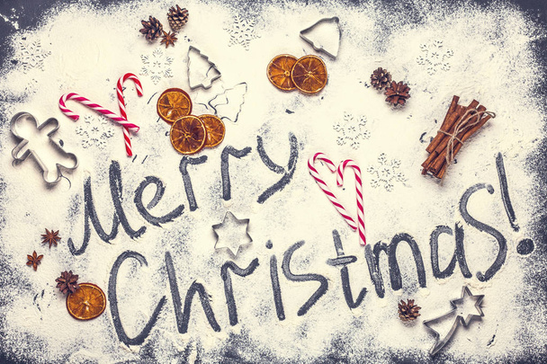 The text of a Merry Christmas from flour on a black background, horizontally - Photo, image