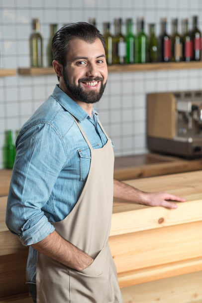 Positive young waiter feeling happy while being at work - Fotografie, Obrázek