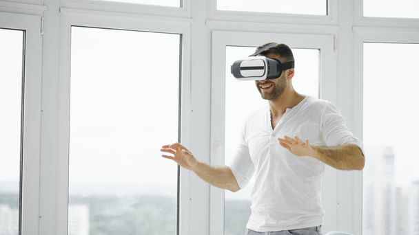 Young man have VR experience with virtual reality headset using hands gestures for control - Φωτογραφία, εικόνα