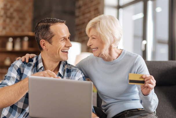 Upbeat elderly mother and son discussing online shopping - Foto, Imagen