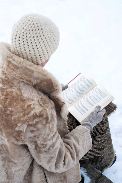 Woman ready a book in winter - Foto, afbeelding